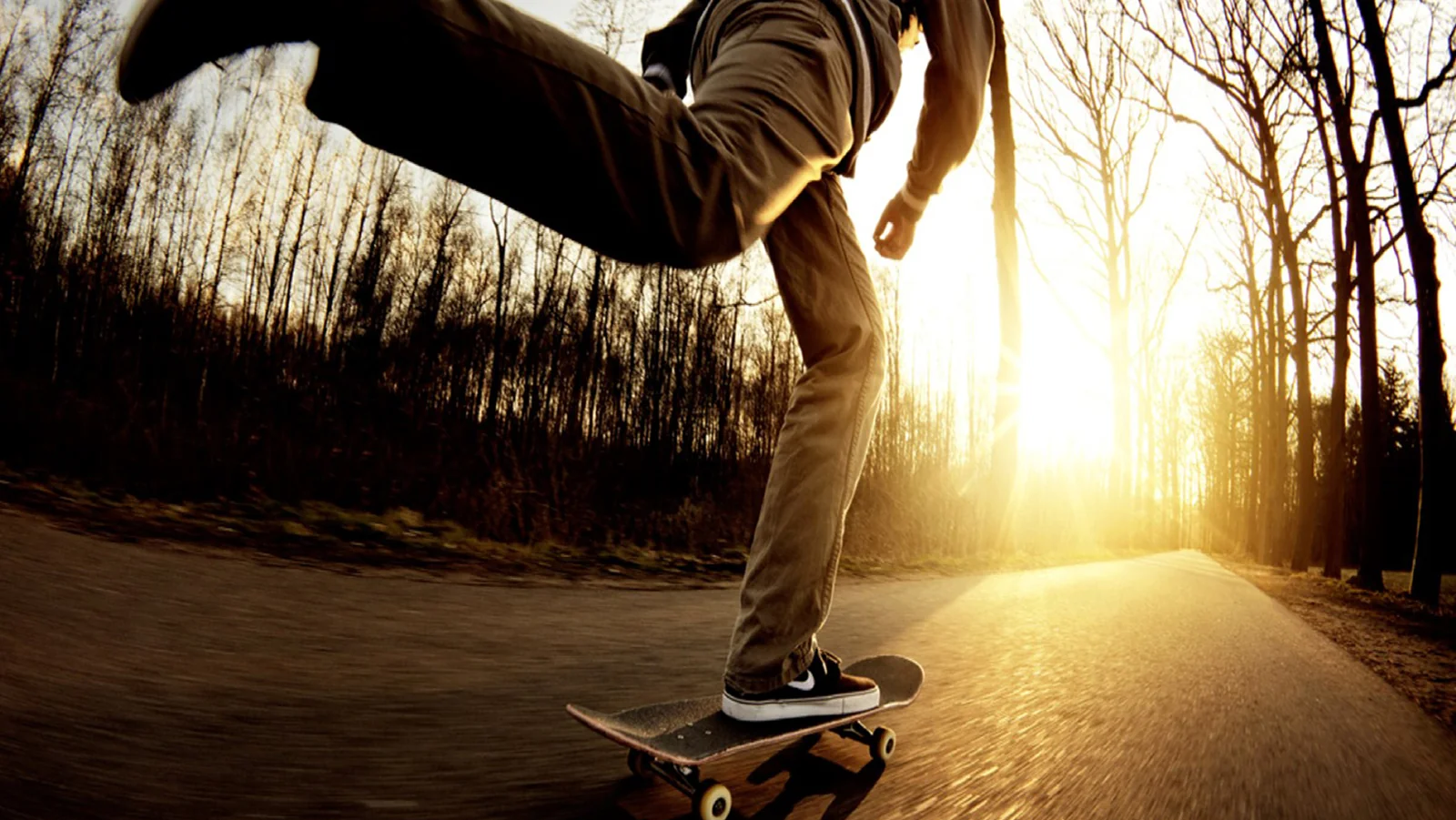 Skateboarder moving through a sunlit road